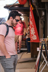 European tourist looking at restaurant menu in a traditional street in Miyajima, Hiroshima, Japan.