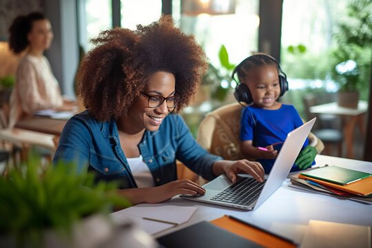 Afro woman helps her son with his computer.