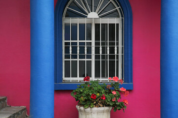 Fototapeta na wymiar Colorful building with beautiful window and steel grilles outdoors