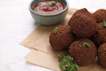 Vegan meat products. Delicious falafel balls and parsley on white table, closeup. Space for text