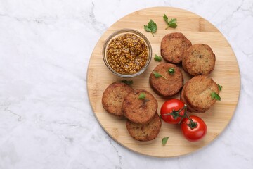 Tasty vegan cutlets, tomatoes and grain mustard on white marble table, top view. Space for text