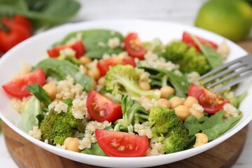 Healthy meal. Tasty salad with quinoa, chickpeas and vegetables on table, closeup