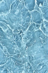 Obraz na płótnie Canvas Blue water with ripples on the surface. Defocus blurred transparent blue colored clear calm water surface texture with splashes and bubbles. Water waves with shining pattern texture background.