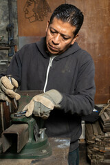 Perfecting the Weld: Herrero Removing Welding Slag from Newly Welded Piece