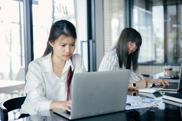 Asian Business woman use laptop to analysis data at office