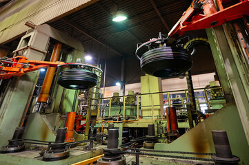 Robotic arms hold new car tires in production plant shop