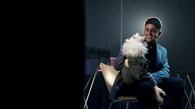 Slow revealing shot of a ventriloquist performing with his puppet onstage