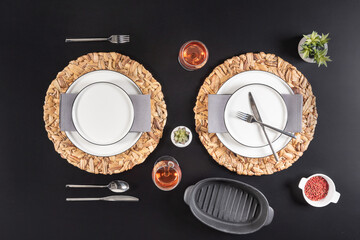 a beautifully-set dining table with elegant crockery, cutlery and an empty plate, a meal is about...