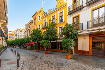 Naklejka premium Morning view before tourists and customers of a row of restaurants and cafes in the historic Barrio Santa Cruz region of Seville, Spain, in the Andalusian region.