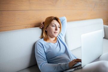 Mid adult woman using a laptop at home