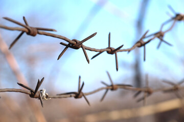 Caution, barbed rusty wire hanging