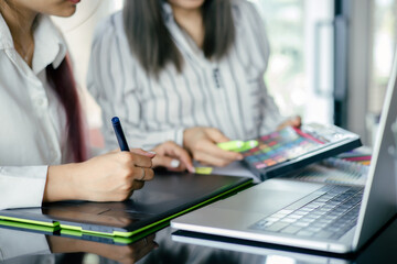 graphic designer working with laptop and color swatch. creative man using digital tablet at modern office.