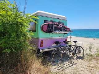 caravan car by the sea bikes surf surfing beach umbrellas trees in summer