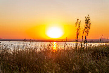 Fototapeta na wymiar Gorgeous orange sunrise on the lake. Beautiful nature.
