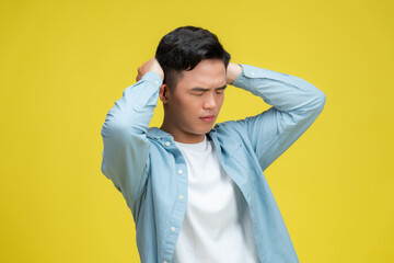 man suffering from headache or thinking over yellow background