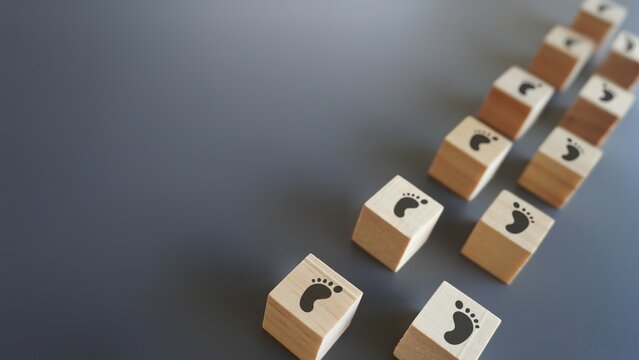 Wooden blocks with footsteps icon and copy space. Progress, step by step, journey, process concept