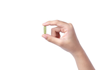 Female hand holding green medicine capsule pill isolated on white background.