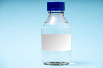 transparent glass bottle for chemical or biological substances on a blue background