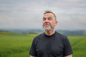 Middle aged man standing in front of a field