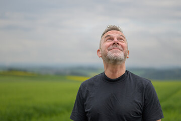Middle aged man standing in front of a field