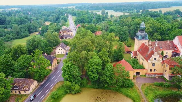Lielstraupe Medieval Castle in the Village of Straupe in Vidzeme, in Northern Latvia. Aerial Dron Shot Lielstraupe Castle United in One Corps With the Church Surrounded by a Park With Pond. Rainy Day