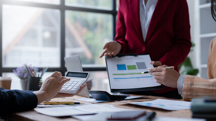 Fototapeta premium Group of business people working together on new project with planning analytical report at meeting. Businesspeople meeting together pointing to graph assess business profits.