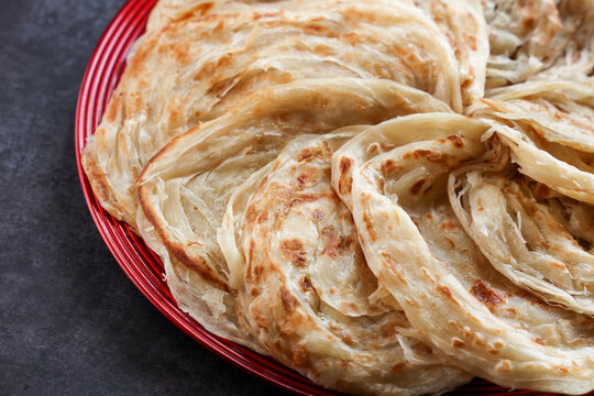 Kerala parathas / porotta / roti / parotta / barotta/ naan layered flatbread made from maida or whole wheat flour. Eat with spicy Asian chicken or beef or egg curry gravy. breakfast dish. Indian food.