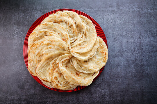 Kerala parathas / porotta / roti / parotta / barotta/ naan layered flatbread made from maida or whole wheat flour. Eat with spicy Asian chicken or beef or egg curry gravy. breakfast dish. Indian food.