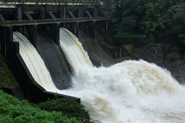Hydroelectric dam on the river with water overflowing the dam after heavy rain in Munnar Idukki...