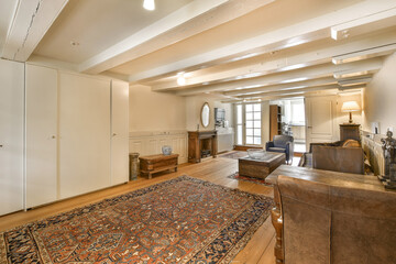a living room with a rug on the floor and an area rug in the middle of the room to the right