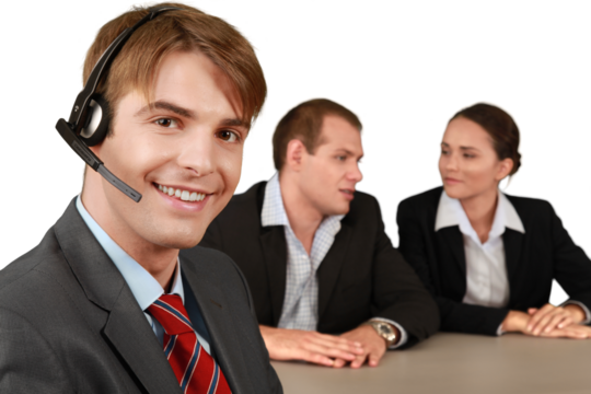 Smiling Businessman with Headset and Talking Collaborators in Background - Isolated