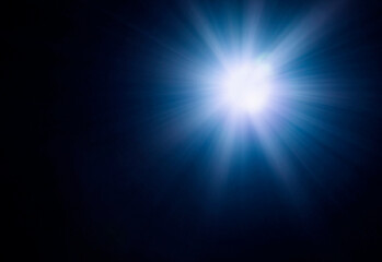 a flash of blue light with a glare on a black background. natural light.