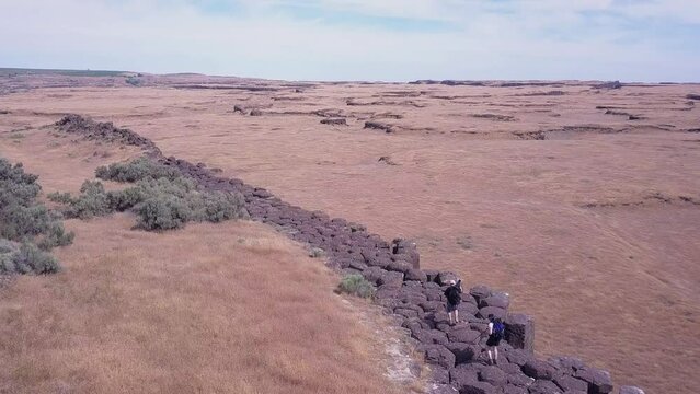 Scablands photographers walk on rock column cliff top in Washington