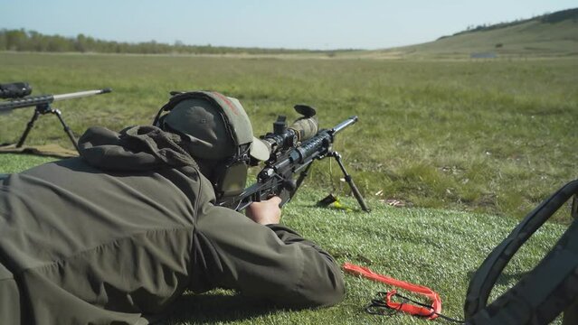 the shooter adjusts the sniper rifle, loads it and makes a shot