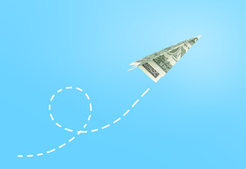 Dollar paper airplane flying against blue background, business concept