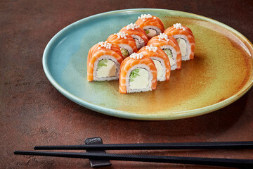 Plate with sushi rolls Philadelphia with salmon and rice balls