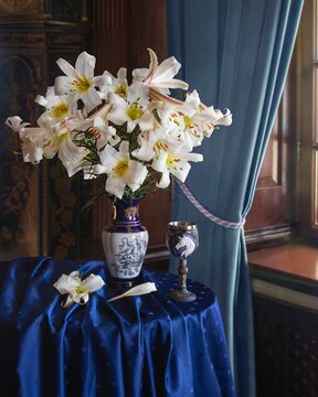 Blue still life with bouquet of white lilies