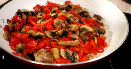 chopped mushrooms and paprika are fried in a pan. cooking in the kitchen. food preparation. smooth camera zoomHigh quality 4k footage