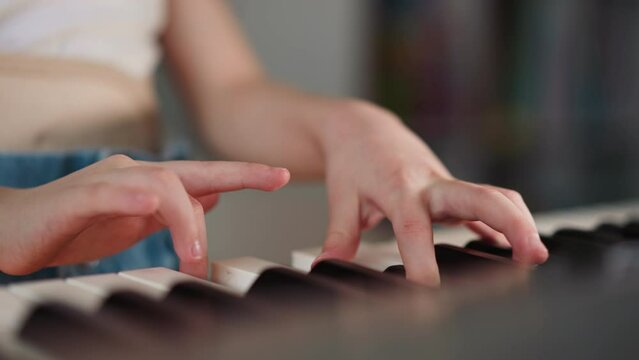 Girl with spinal cord injury plays piano standing in room at home. Talented child practices music during rehabilitation closeup on blurred background