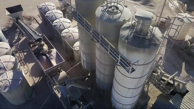 aerial view of a cement and aggregate factory showing silos, conveyor belts and heavy machinery
