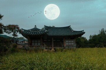 Korean traditional house in the middle of rice field at full moon night, rural area near Seoul,...