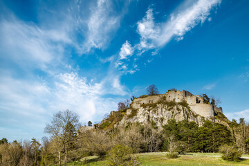 Fototapeta na wymiar Bottom view of a hill with the ruins of the Hohentwil castle on its top against a blue sky