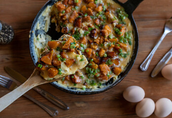 Sweet potatoes with eggs and bacon in a frying pan
