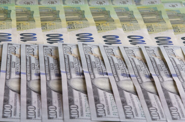 One hundred dollar bills next to one hundred euro bills., Currency exchange rate concept, selective focus.