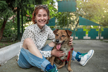 Animal shelter volunteer with dogs. Dog at the shelter. Lonely dogs in cage with cheerful woman...