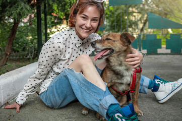 Animal shelter volunteer with dogs. Dog at the shelter. Lonely dogs in cage with cheerful woman volunteer