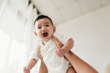 Asian adorable baby in a good mood, Enjoy playing with parent. A parent holding little baby and...