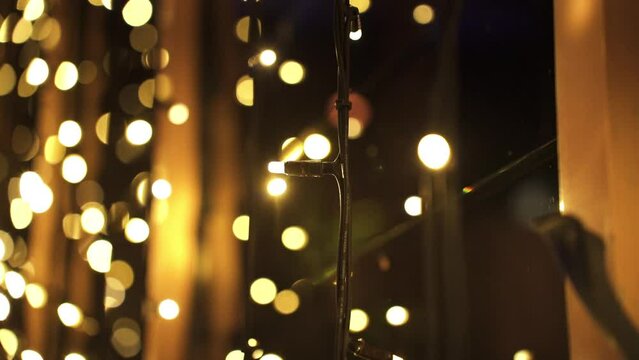 Illuminated Fairy Lights At Night Hanging Against A Window - close up