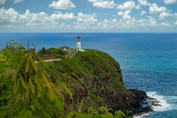 Scenic view of Kilauea Lighthouse on the coast of Kauai, Hawaii from Kilauea Point overlooking the Pacific Ocean and a wildlife refuge with flourish green vegetation