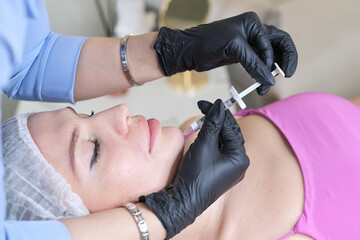 detailed view of a hyaluronic acid injection procedure, focusing on the chin area. experiences or new advancements in cosmetic procedures.